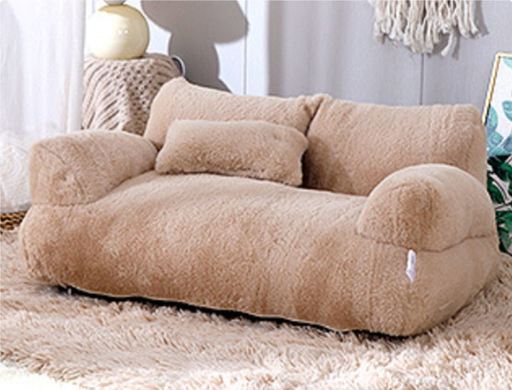 Cat lying on plush pet sofa with pillow