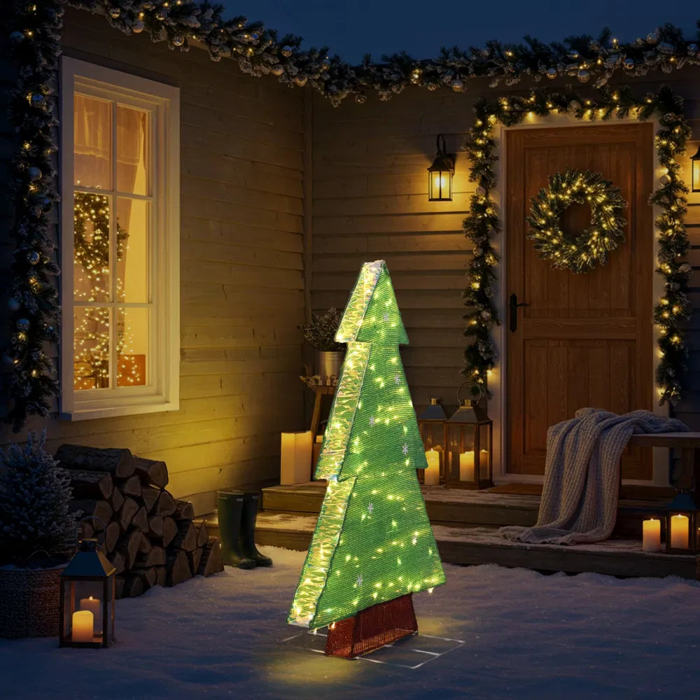 Lit tinsel Christmas tree silhouette outdoors