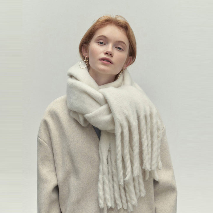Woman wearing long ivory scarf with tassels