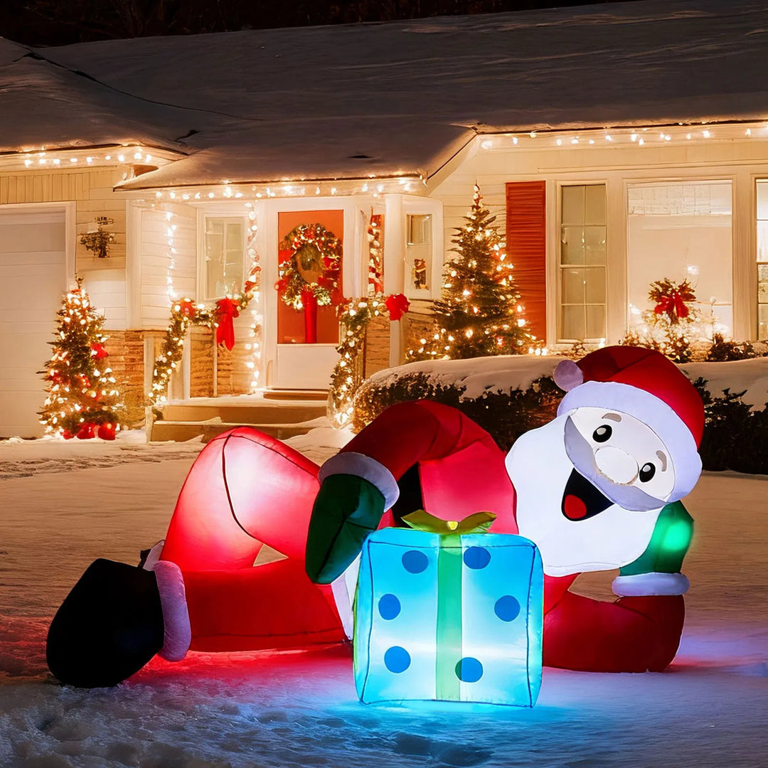 Inflatable Santa lying beside a gift box