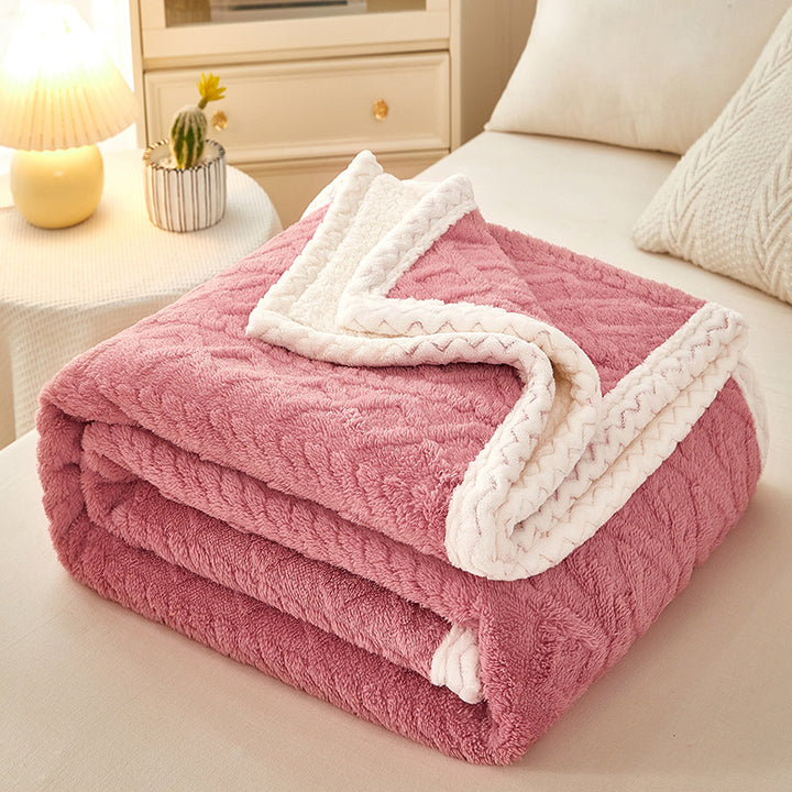 Thick sherpa fleece blanket folded on bed