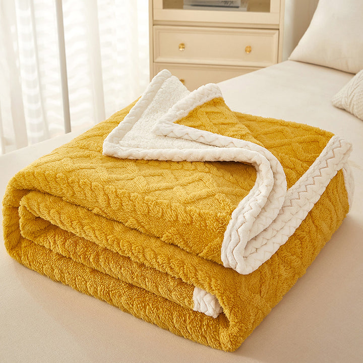Thick sherpa fleece blanket folded on bed